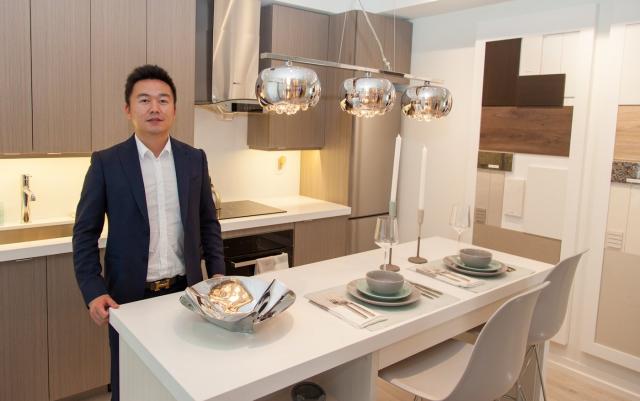 Mr. Mao shows off the model kitchen, with a range of finishes visible 